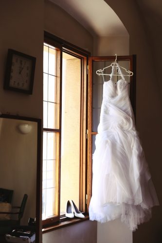 svatební šaty visící na okně